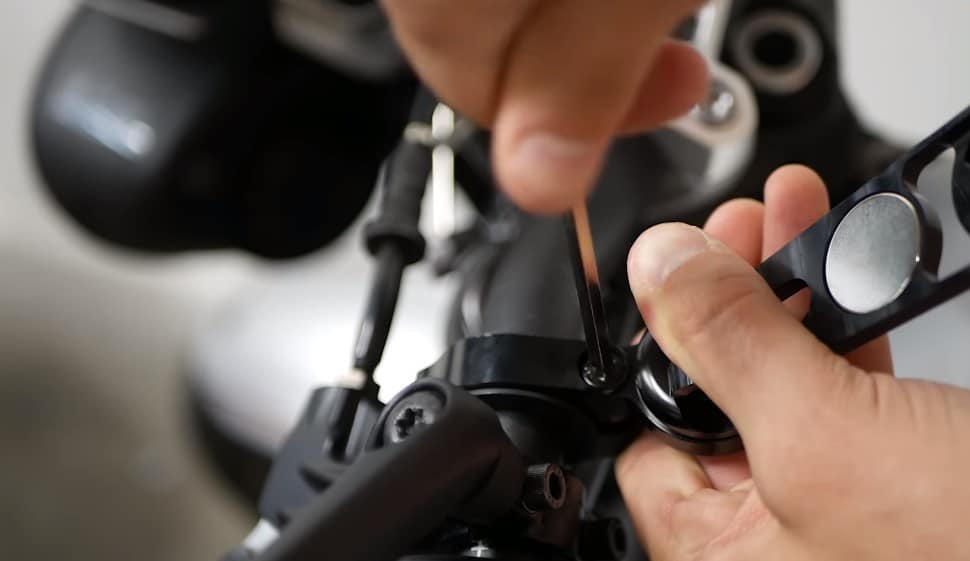 Attaching a universal phone/GPS mount securely to the handlebars of a motorcycle, designed to fit various motorcycle types, including adventure (ADV) and naked bikes.