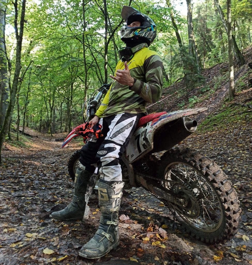 Sporting neon yellow AGVSPORT reflective motorcycle clothing to enhance visibility, even amidst mud splatters. Mounting the GoPro on the AGV AX-8 helmet provides an excellent trail view without compromising awareness of terrain depth, and the tall ADV boots serve as a crucial injury prevention measure.