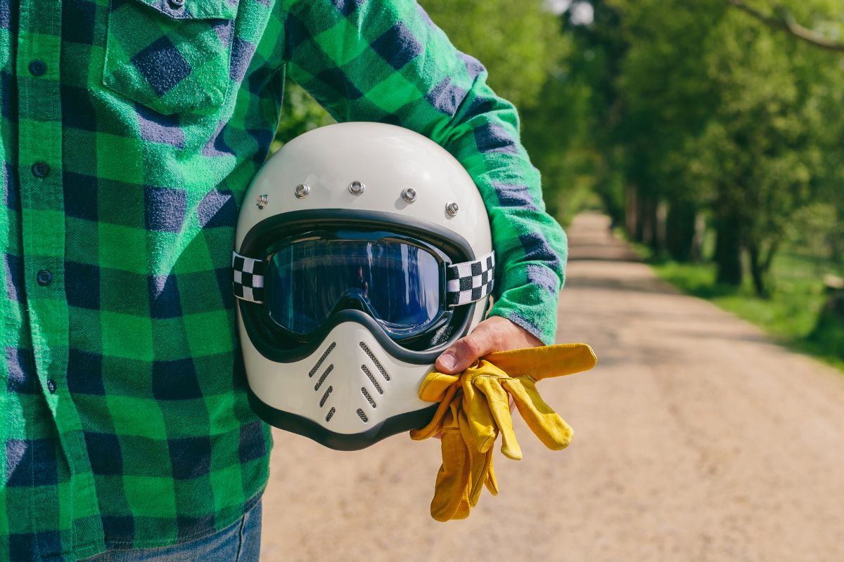 man holding motorcycle helmet to show the safest motorcycle helmet brands