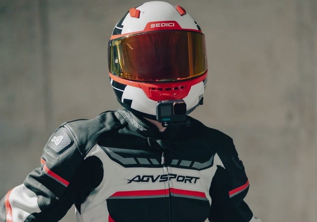 The white/black/red graphics Sedici Strada II Forza full-face helmet with a lightweight fiberglass and DuPont™ Kevlar® fiber construction, weighing just 3.3 lbs. It offers strength without sacrificing comfort, allowing for easy mounting of a GoPro on the chinbar.