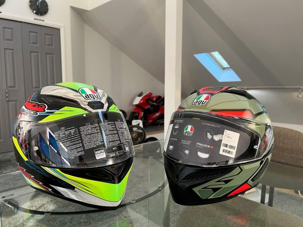 On the left is the AGV K1 Dundee Matte Lime Red Helmet, while on the right is the AGV K3 Decept Matte/Black/Green. My RS125R Honda road race bike is in the background.
